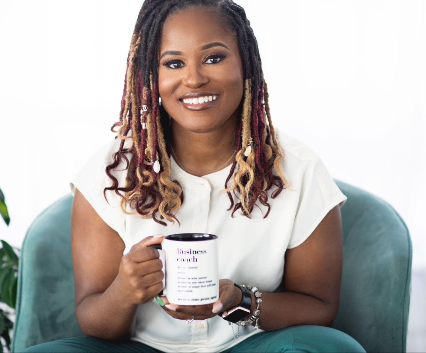 Yvette Howard, LCSW, founder of Boss Clinician, smiling and holding a mug that reads business coach